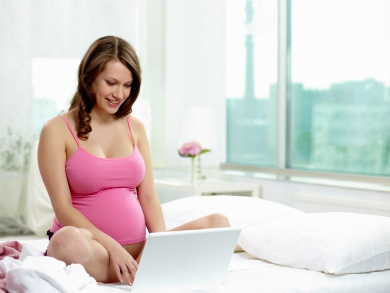 Kobieta w ciąży przed laptopem